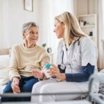 Young careworker talking to patient