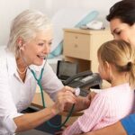Female GP checking child with a stethoscope
