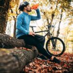 Cyclist in woods drinking from bottle