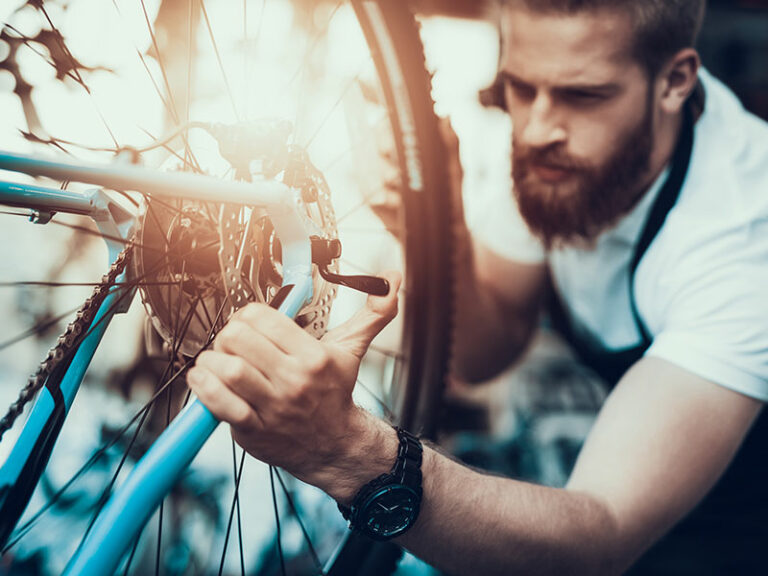 Man Inspecting Bicycle Wheel
