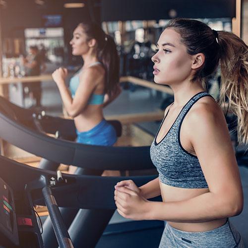 Women running on treadmills in a gym