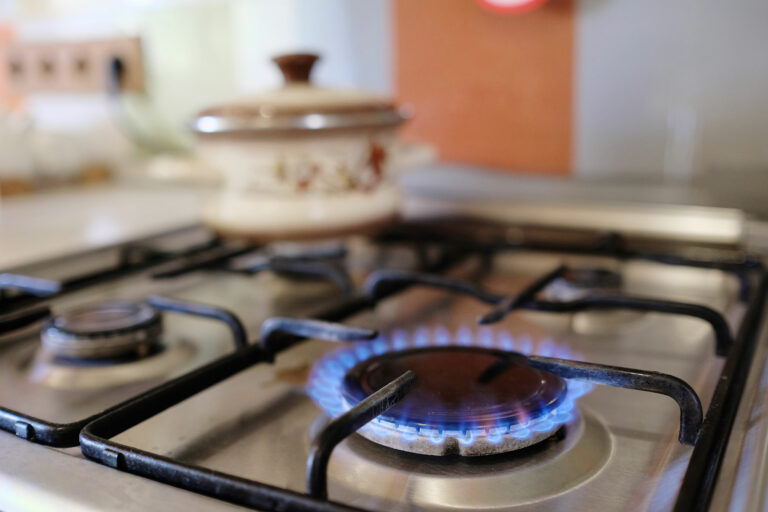 A photo of a gas stove that's lit, for gas safety blog post.